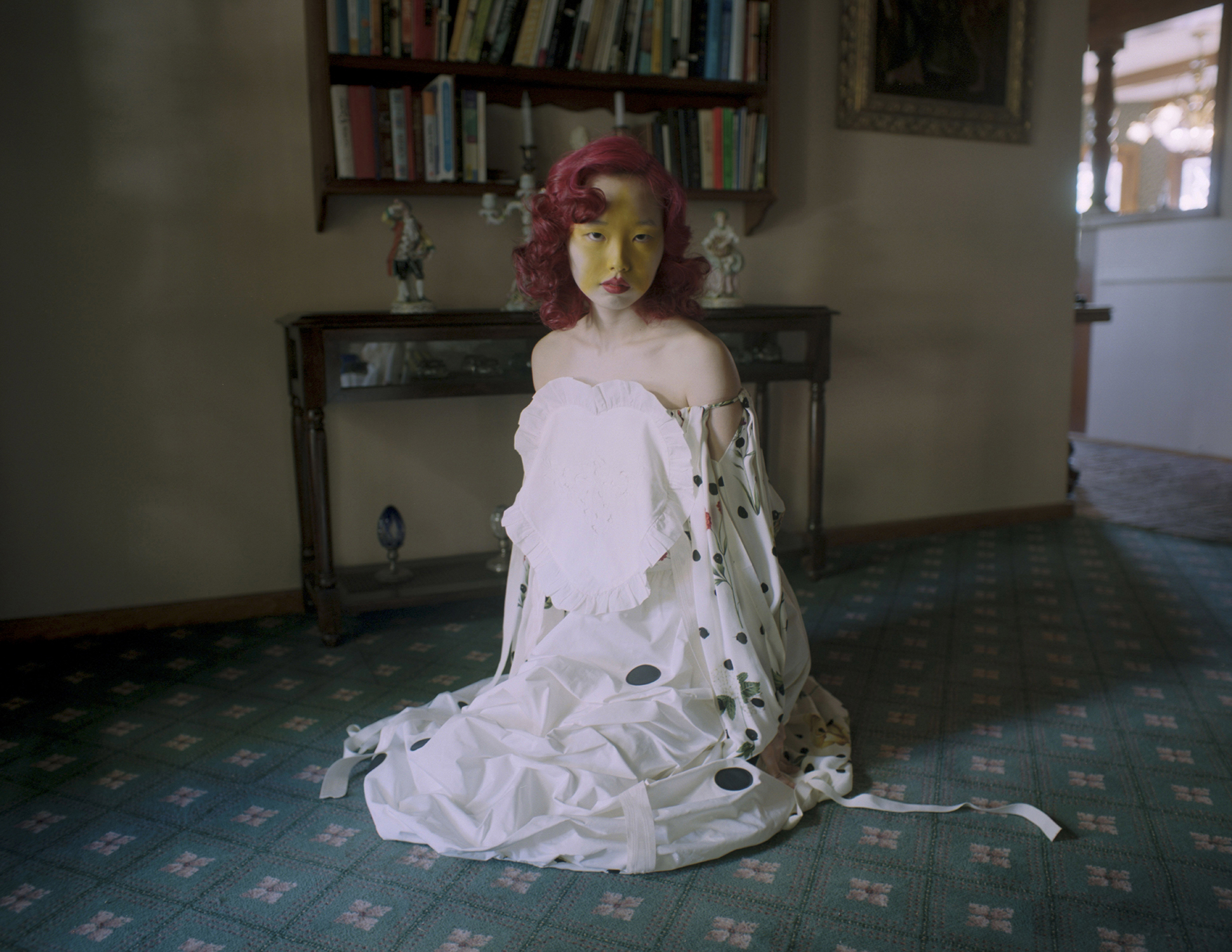 A model with yellow star makeup seated in a study